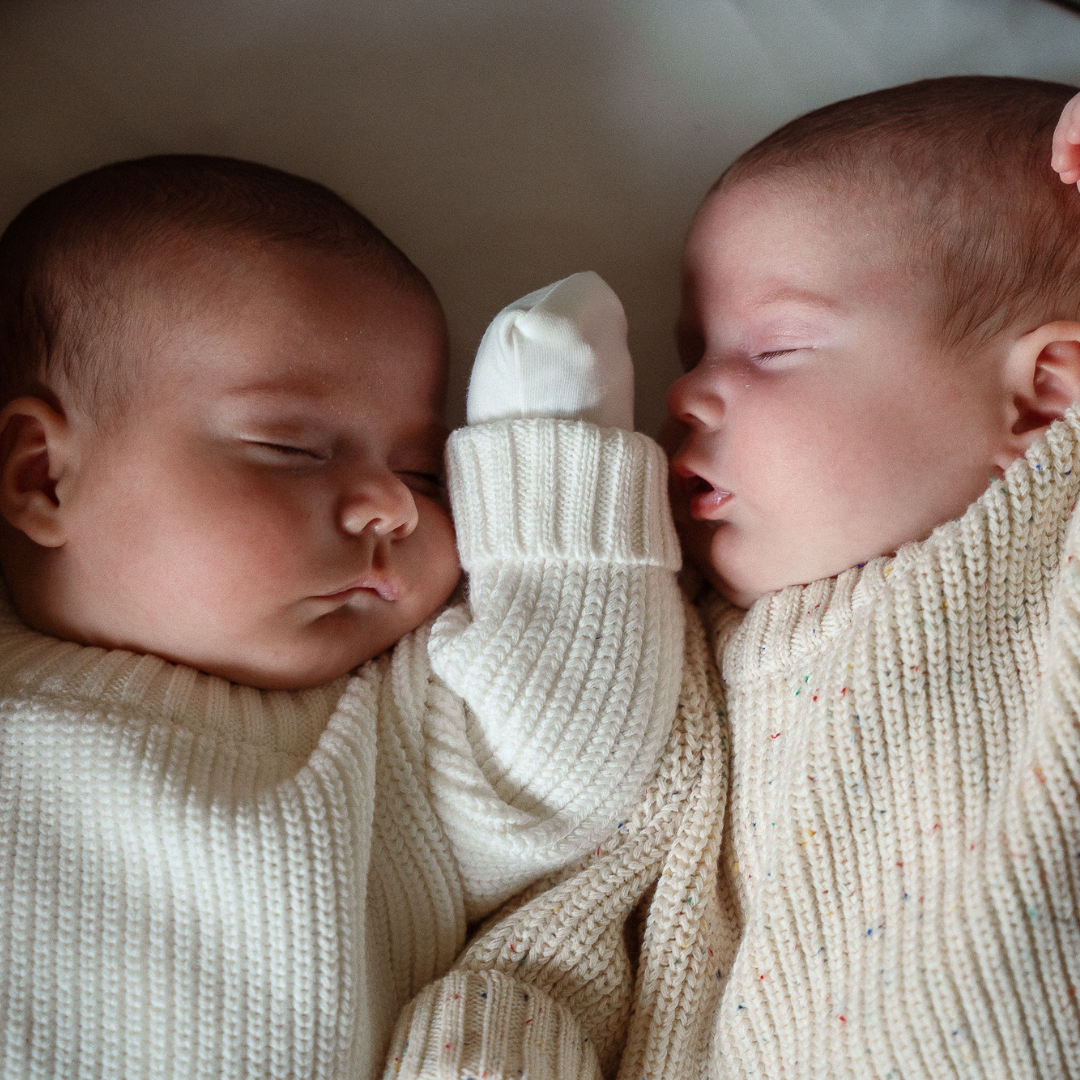 Baby in a Pip + Phee cotton sleeper with a knit sweater layered over top